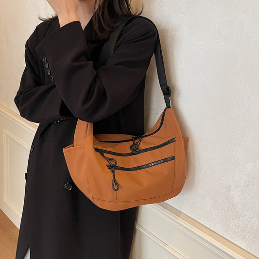 Front view of dumpling-shaped women’s canvas shoulder bag