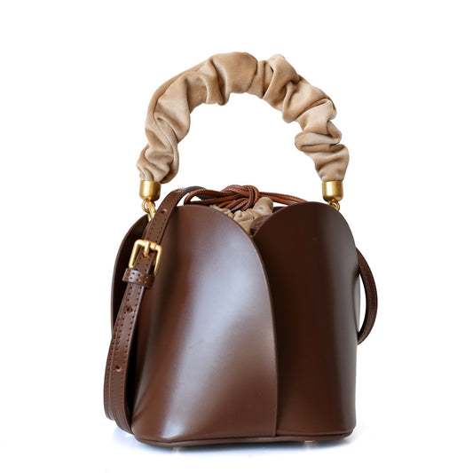 Flower bucket bag in cowhide leather with elegant floral design.