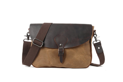 Brown leather satchel bag with a strap on a white background