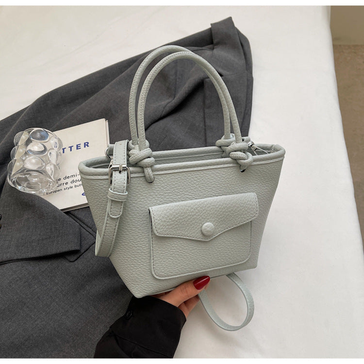 Light gray handbag held by a person