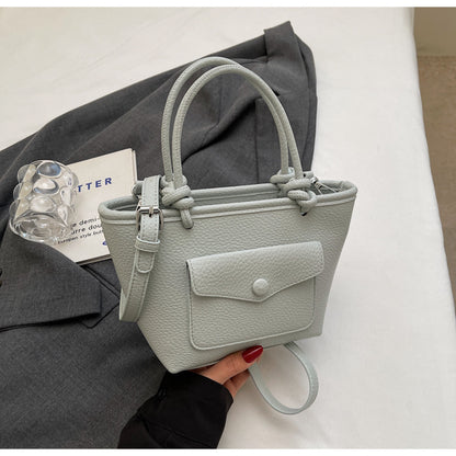Light gray handbag held by a person