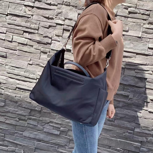 Black waterproof nylon shoulder bag with leather details