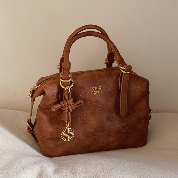 Compact brown oval shoulder handbag with sleek strap