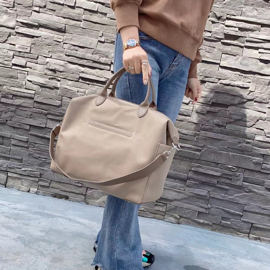 Side view of large waterproof nylon tote with leather trim