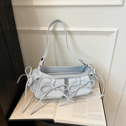 Woman wearing pleated PU leather handbag with tassel bow