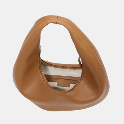 Model holding brown minimalist cowhide shoulder purse