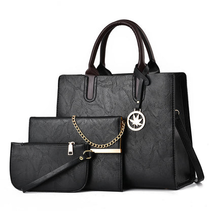 Black handbag set with a smaller pouch and chain detail on a white background