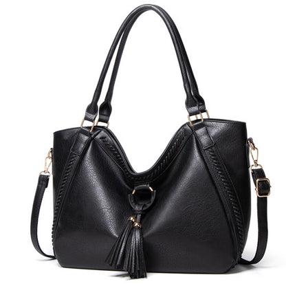 Black handbag with a tassel on a white background