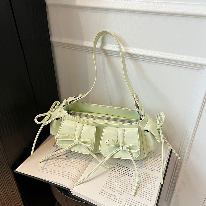Close-up of tassel bow and pleated surface of handbag