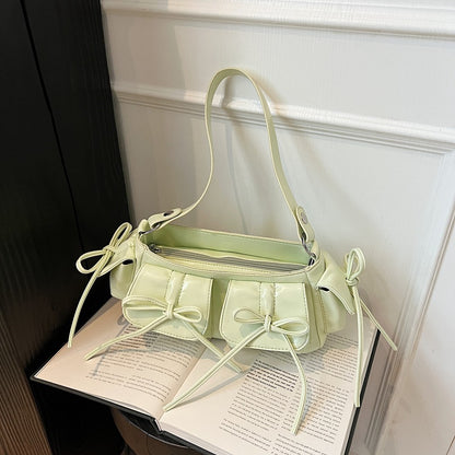 Close-up of tassel bow and pleated surface of handbag