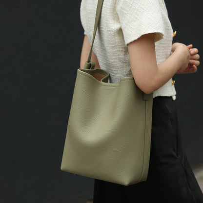 Size comparison of leather crossbody bucket bag next to personal items
