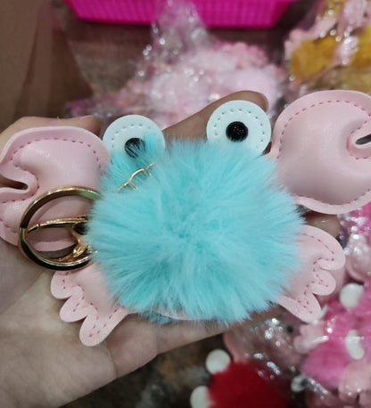 urquoise fuzzy keychain with googly eyes held