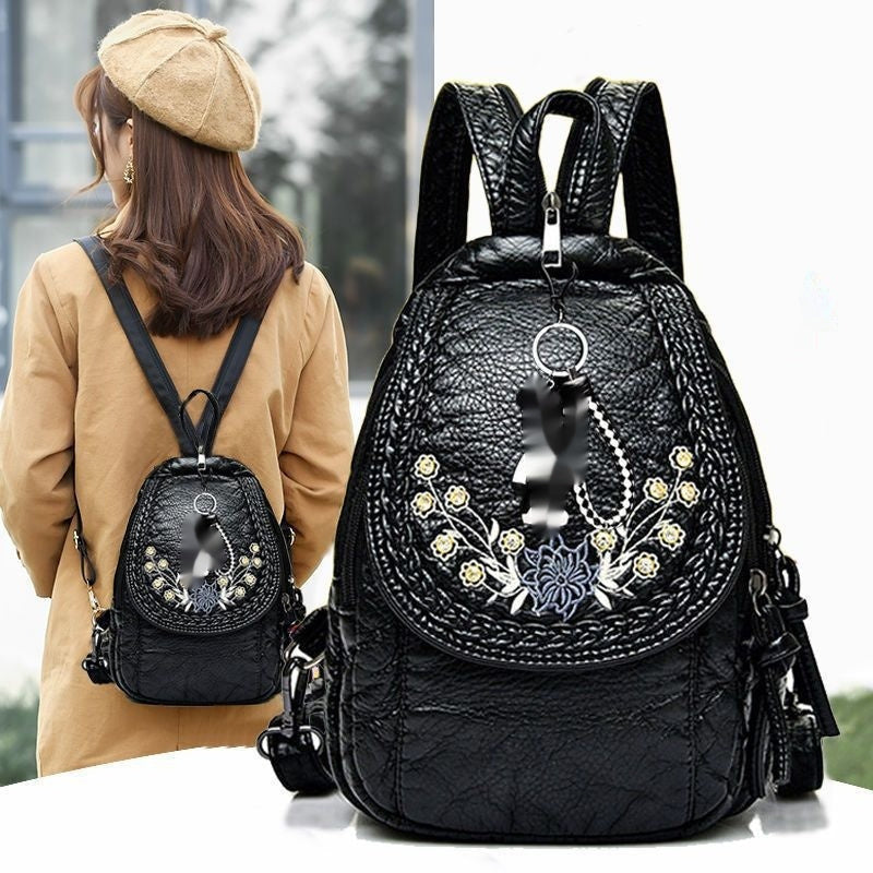 Black backpack with decorative elements and a woman wearing it outdoors.